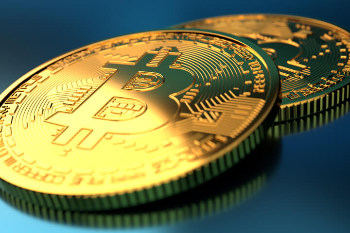 Two Bitcoins on blue background with hard spot light