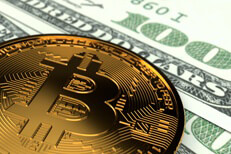 Bitcoin on US currency Single Bitcoin laid on top of two 100 dollar bills