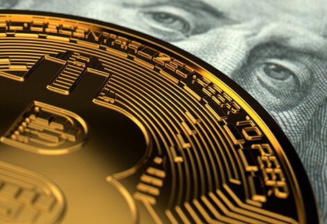 Ben Franklin eyeing bitcoin Close-up photo of Bitcoin detail with Benjamin Franklin currency eyes behind it