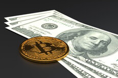 Single bitcoin on US currency Single Bitcoin laying on top of three U.S. one hundred dollar bills