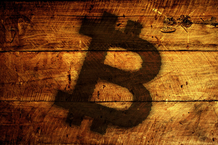 Rough wood planks with Bitcoin logo burned into surface