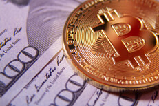 Bitcoin on one hundred dollar bills Free photo of a bitcoin on several one hundred dollar bills