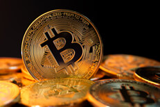 Pile of bitcoins with one on edge Bitcoin standing on edge in pile of bitcoins with black background