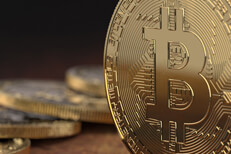 Close view of Bitcoin with coins Close up view of Bitcoin on edge with blurred coins in background
