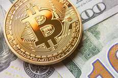 Close view bitcoin on US 100 dollar bills Close view of bitcoin on scattered 100 dollar bills