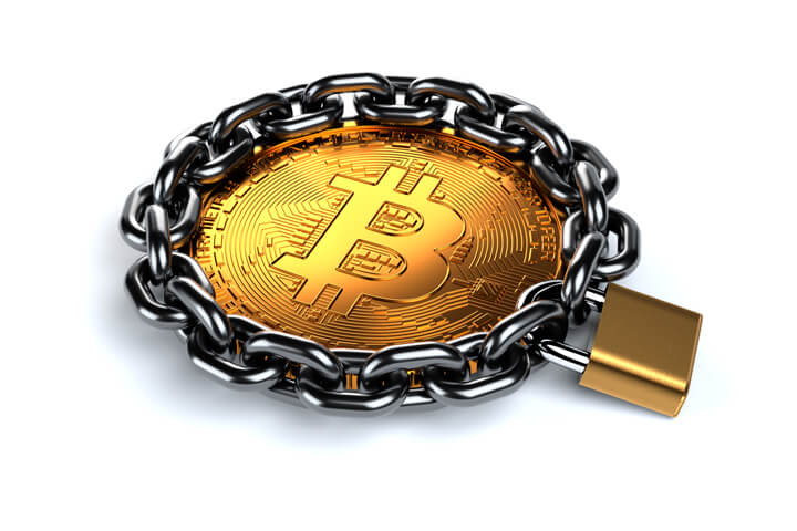Bitcoin with hefty chain wrapped around it and locked with a brass padlock