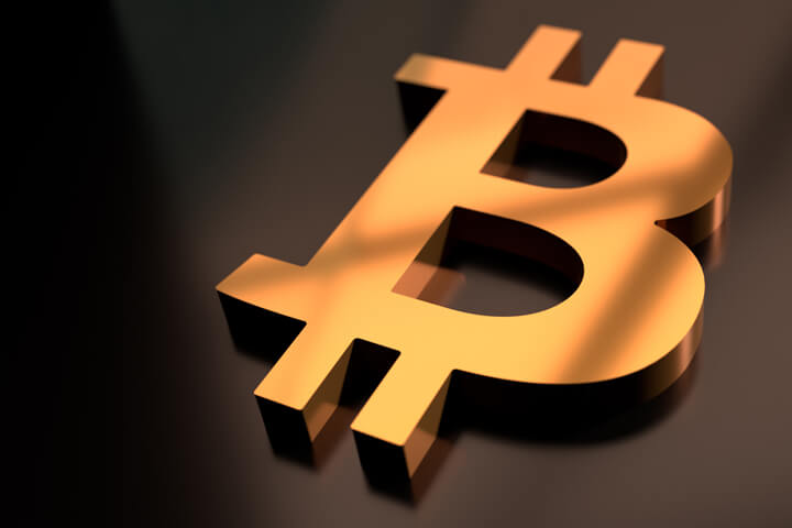 Gold metallic Bitcoin B icon on black glossy surface with reflection