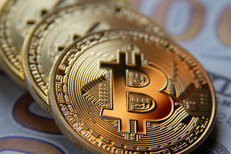 Angled row of Bitcoins on Benjamins Bitcoins at angle on US 100 dollar bills