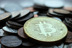 Bitcoin with tarnished U.S. coins Bitcoin lying on a large pile of assorted U.S. currency coins showing signs of tarnish