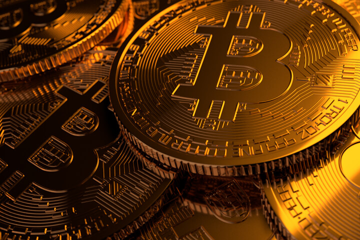 Pile of Bitcoins scattered with hard gold light to right