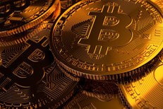 Bitcoins scattered with contrasting lighting Pile of Bitcoins scattered with hard gold light to right