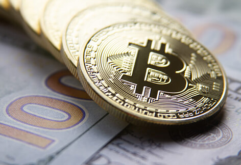 Bitcoin row on 100 dollar bills Bitcoins in a row on US 100 dollar bills in background