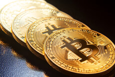 Bitcoins on reflective texture Bitcoins in a row on reflective black textured surface