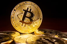 Bitcoin standing in pile Bitcoin on edge with other scattered bitcoins in foreground