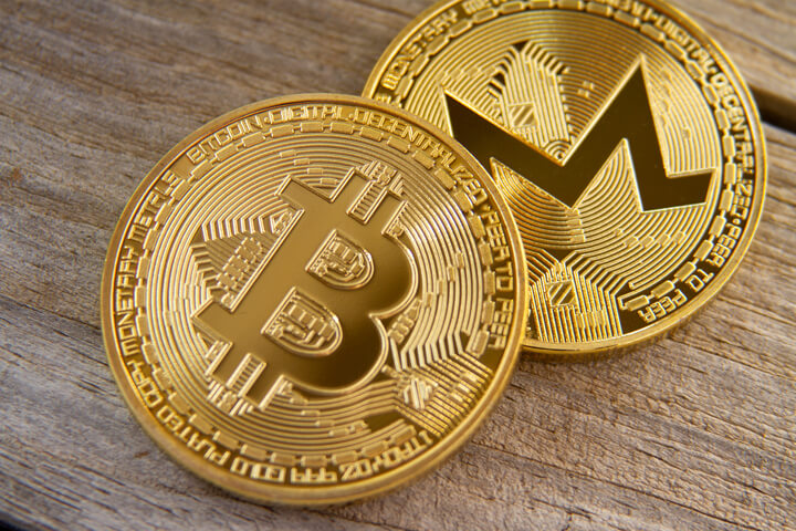 Bitcoin and Monero coin on wood background