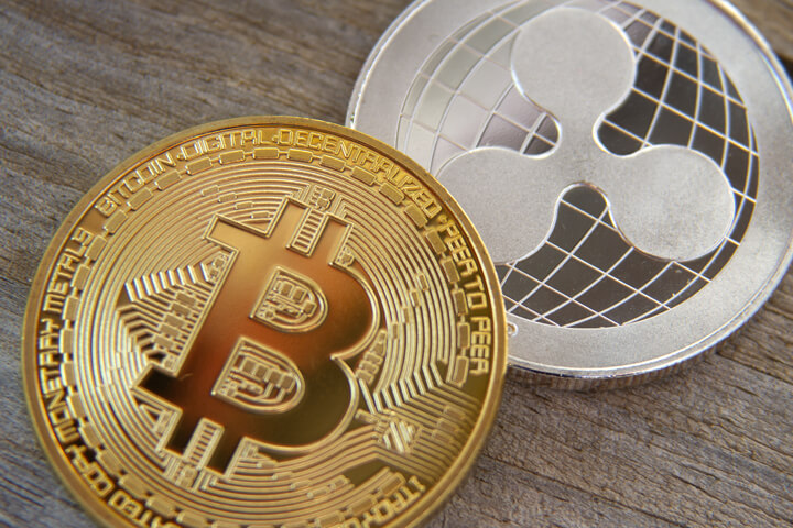 Bitcoin and Ripple coin on wood background