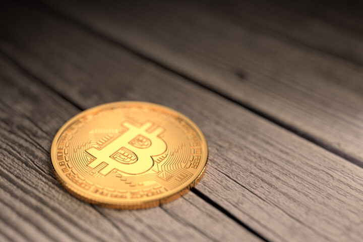 Bitcoin with spotlight lying on old wood planks