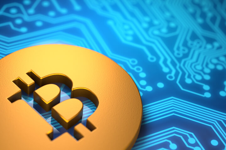 Bitcoin concept coin laying on blue circuit board