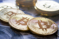 Bitcoins laid on 100 dollar bills Bitcoins in stacks and a row on top of U.S. 100 dollar bills