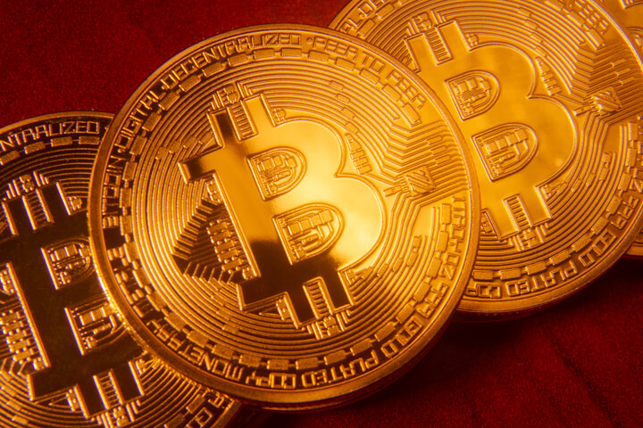 Bitcoins in orderly stack on rich cherry wood desk