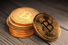 Stack of Bitcoins with one leaning coin on old weathered wood boards