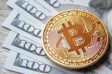 Bitcoin on fanned 100 dollar bills Bitcoin on five 100 dollar bills fanned on wood background