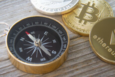 Ethereum coin, Bitcoin, and Litecoin with compass Ethereum coin, Bitcoin, and Litecoin next to navigation compass on wood surface