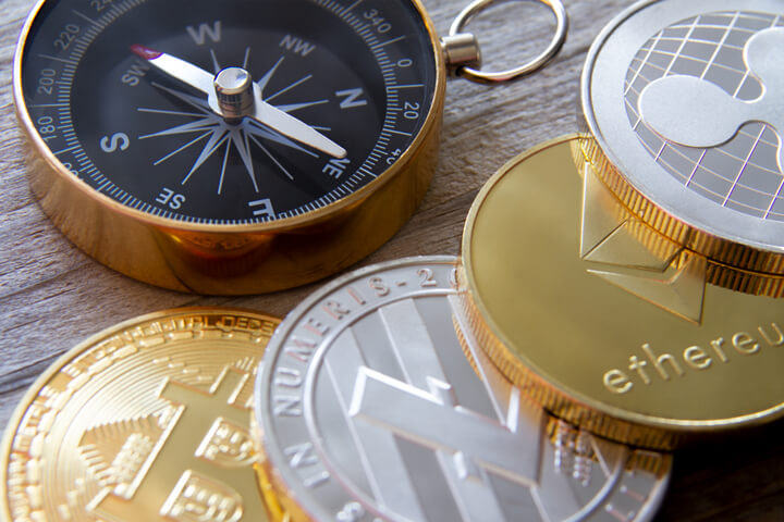 Bitcoin, Litecoin, Ethereum, and Ripple coins with navigational compass