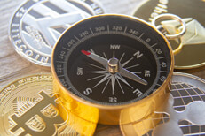 Compass on cryptocurrency coins Four cryptocurrency coins with navigational compass on top