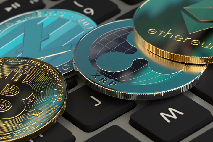 Bitcoin, Litecoin, Ripple XRP, and Ethereum coin on Apple MacBook Pro keyboard