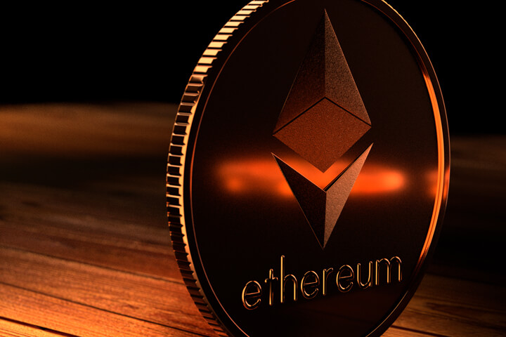 Ethereum coin on edge on wood surface with orange highlight reflection