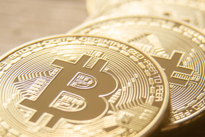 Close view of curved row of Bitcoins on a blurred wooden background