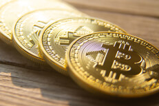 Four bitcoins in a row Angled view of four bitcoins in a row on wood planks