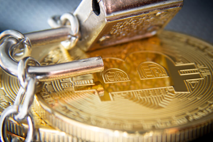 Stack of bitcoins wrapped in chains with unlocked padlock concept for hacked Bitcoin wallet