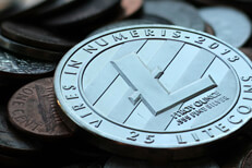 Litecoin on currency pile close Close up photo of Litecoin cryptocurrency coin on top of an assorted pile of U.S. currency coins