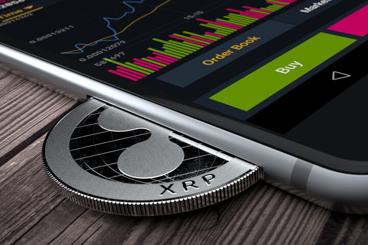 iPhone with Ripple XRP coin inserted into slot concept for mobile XRP apps, profits, or trades