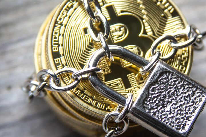 Top view photo of a stack of Bitcoins secured with chains and a padlock