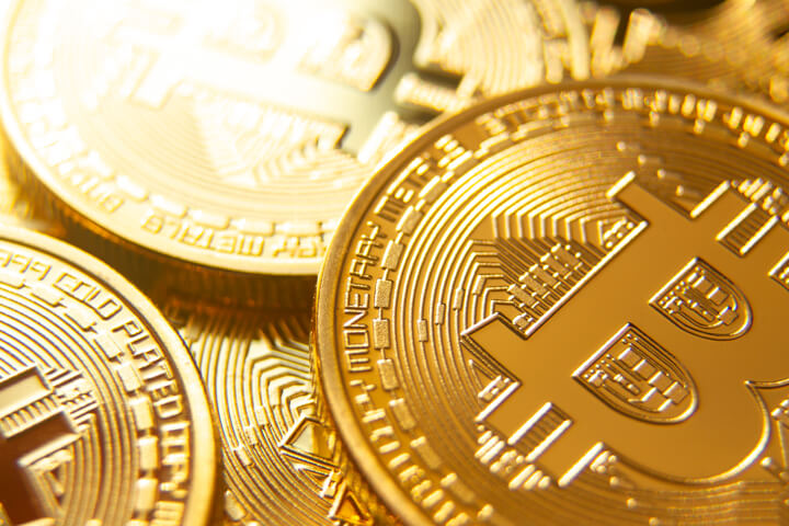 Close up view of a scattered random pile of bitcoins with back light