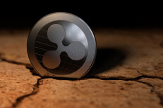Ripple coin in cracked earth Ripple crypto coin stuck in crack left from dry desert mud
