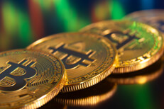 Row of Bitcoins reflecting stock charts Row of Bitcoins reflecting stock price chart in computer monitor