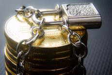 Stack of secured Bitcoins Stack of Bitcoins locked with padlock and chains on dark carbon fiber background