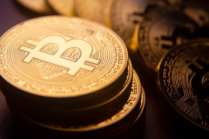 Stack of bitcoins in foreground with curved row of coins in background