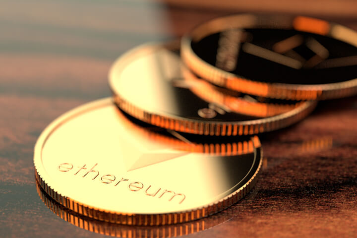 Three Ethereum crypto coins on wood desk reflecting window light