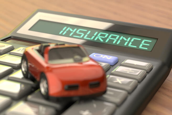 Insurance calculator with focus on LCD reading Insurance with small red toy car