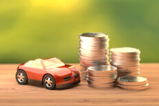 Red toy car next to stacks of coins
