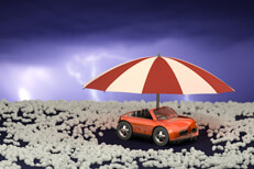 Toy car under umbrella after hail storm Toy car under umbrella surrounded by hail stones with lightning in sky after a hail storm