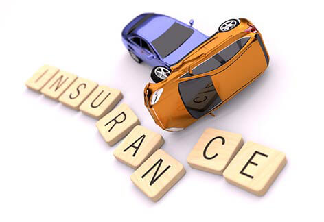 Two car collision displacing wood letters spelling insurance isolated on white