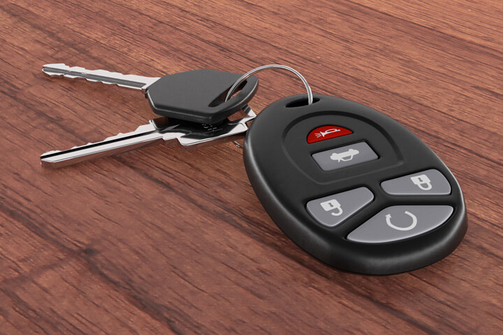 Car keys and key fob on wood desk