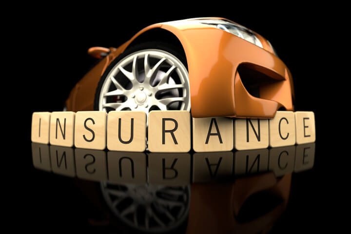 Orange car with bumper wrapping over wood insurance letters on black shiny background with reflection