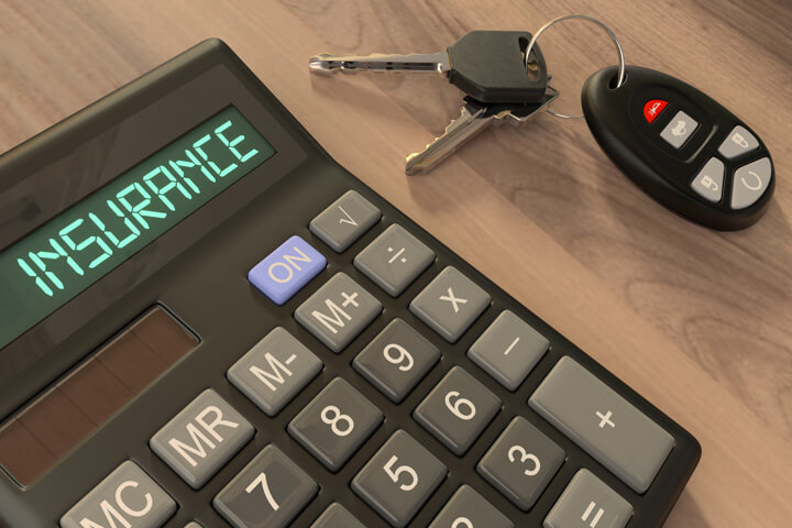 Insurance calculator on desk with car keys and key fob